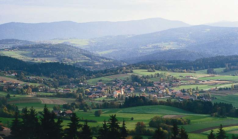 Blick auf die Gemeinde Prackenbach und die umlegende Bergkulisse.