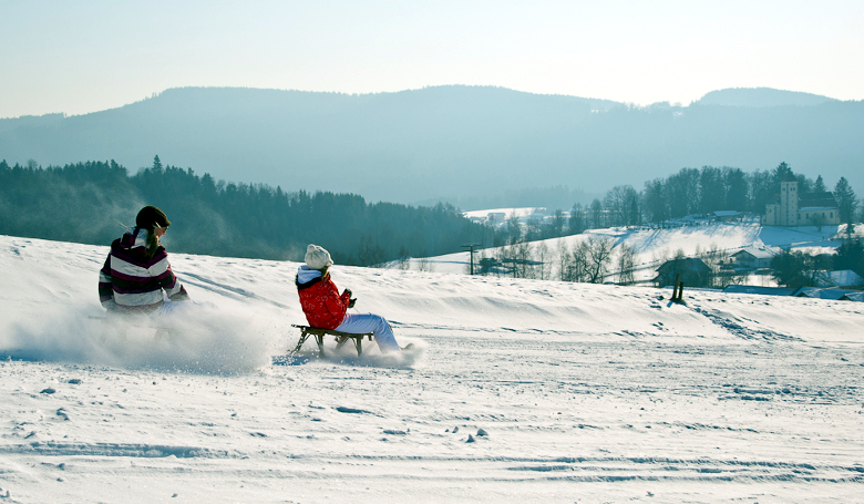 Schlittenfahren durch die verschneite Winterlandschaft.