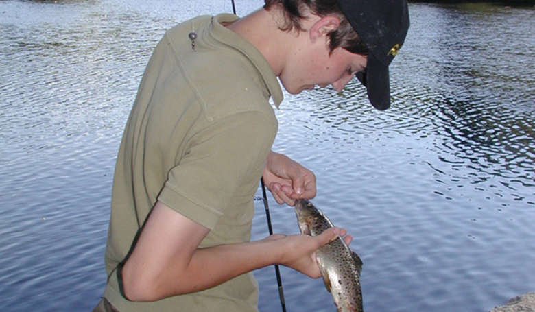 Junger Angler beim Preisfischen in Regen. Nur der größte Fisch bringt den Hauptpreis oder den Siegertitel.
