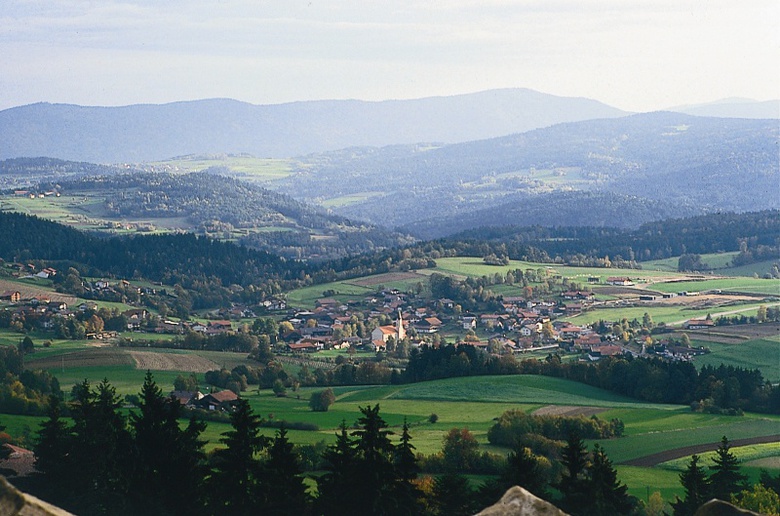 Blick auf die Gemeinde Prackenbach und die umlegende Bergkulisse.