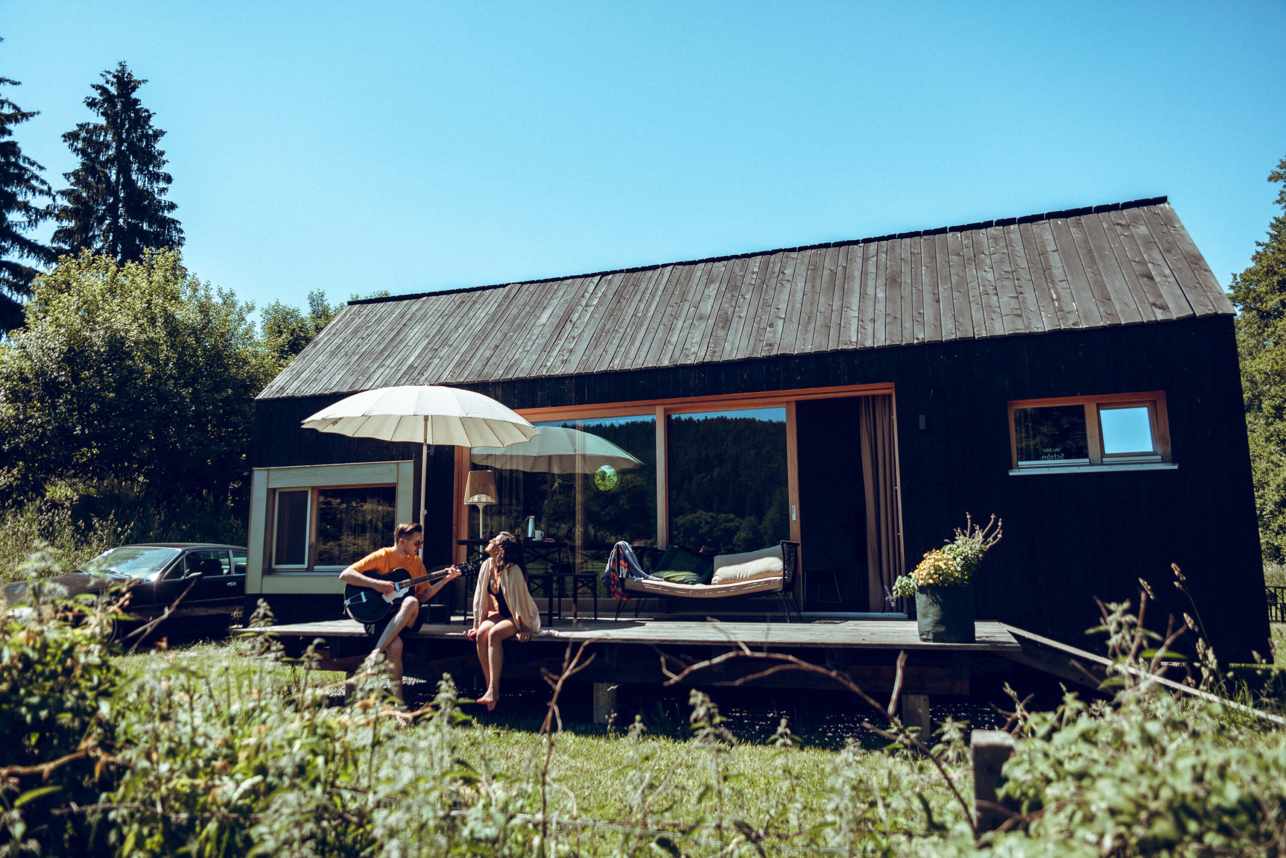 Neue Tiny-Häuser im Adventure Camp Schitzmühle mit Holzterrasse, schönem Wohnbereich und Platz für 4 Personen.